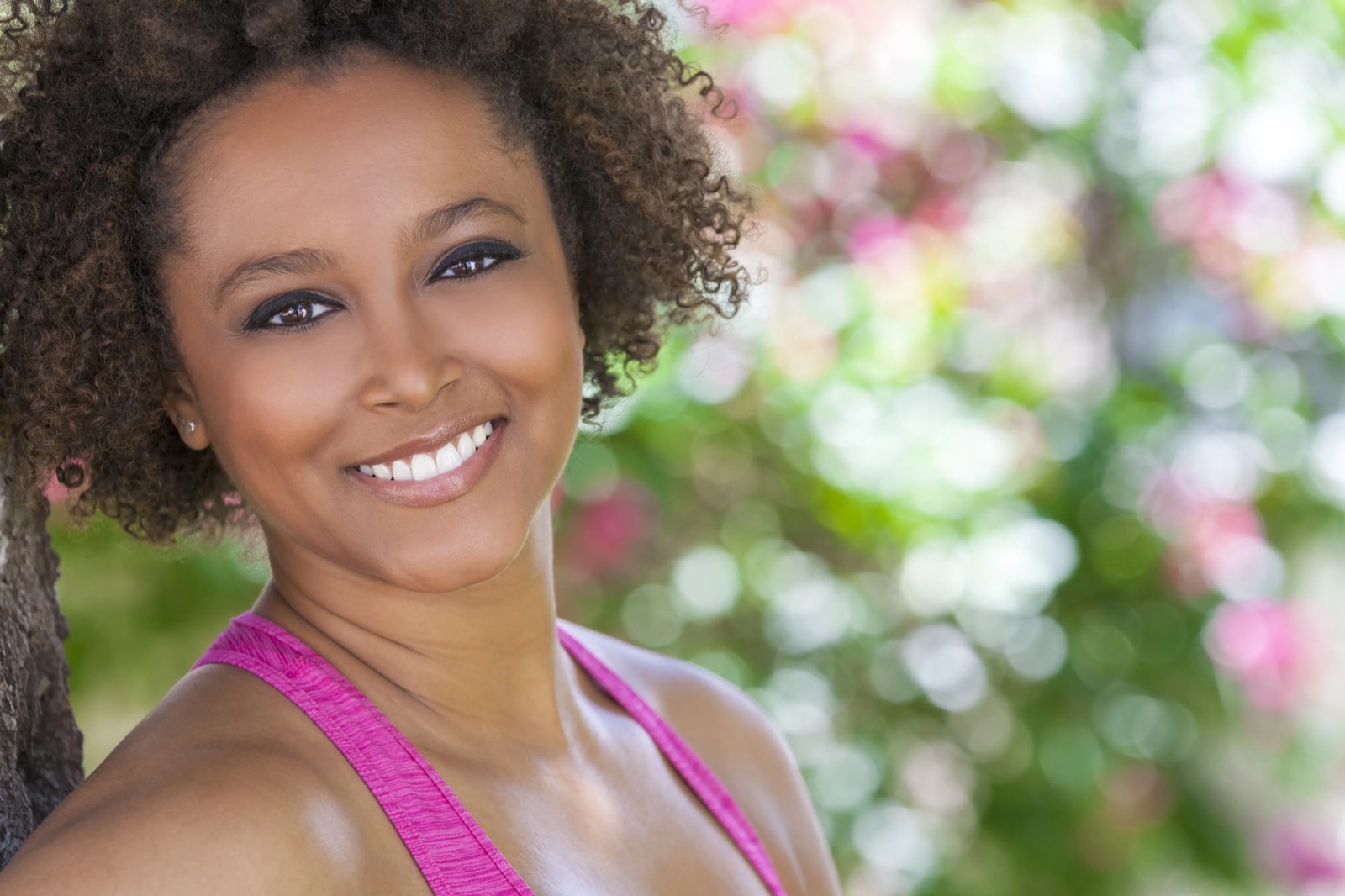 A patient smiling outdoors in a garden — wellness imagery from the Atlas Health Institute website